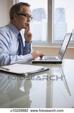 Stock Image - Businessman looking at laptop. Fotosearch