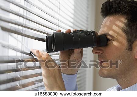 Businessman looking out window through binoculars View Large Photo Image Stock Image - Businessman looking out window through binoculars. Fotosearch