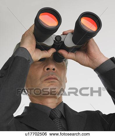 Businessman looking through binoculars View Large Photo Image Stock Photograph - Businessman looking through binoculars. Fotosearch