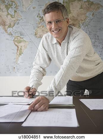 Stock Image - Businessman organizing paperwork. Fotosearch