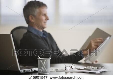 Stock Photo - Businessman reading paperwork. Fotosearch