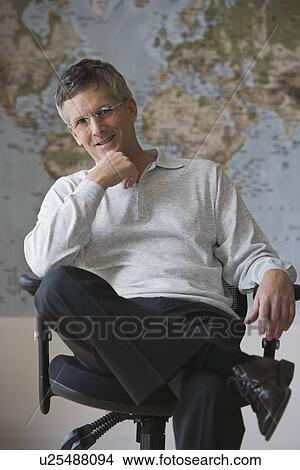 Picture - Businessman sitting in front of world map. Fotosearch