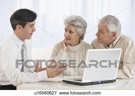 Businessman talking to senior couple in home View Large Photo Image Stock Photo - Businessman talking to senior couple in home. Fotosearch