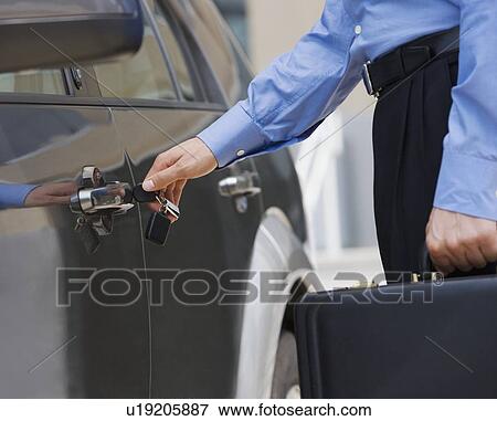 Businessman unlocking car door View Large Photo Image Stock Photo - Businessman unlocking car door. Fotosearch