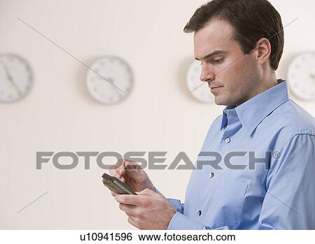 Stock Photograph - Businessman using electronic organizer. Fotosearch