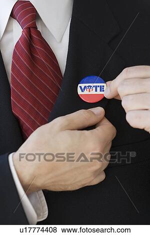 Stock Photo - Businessman wearing Vote pin on lapel. Fotosearch