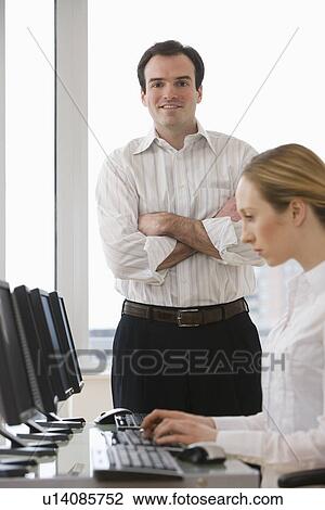 Businessman with arms crossed behind businesswoman View Large Photo Image Stock Image - Businessman with arms crossed behind businesswoman. Fotosearch