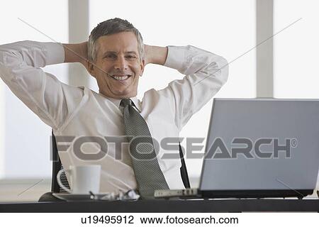 Businessman with hands behind head View Large Photo Image Stock Image - Businessman with hands behind head. Fotosearch