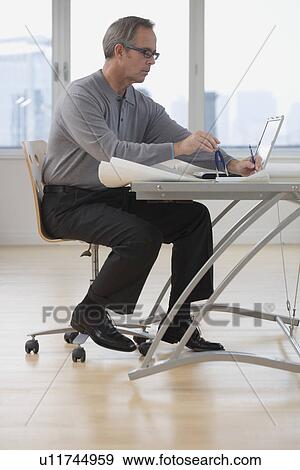 Businessman working at desk View Large Photo Image Stock Photo - Businessman working at desk. Fotosearch