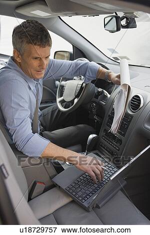 Businessman working in car View Large Photo Image Stock Photo - Businessman working in car. Fotosearch