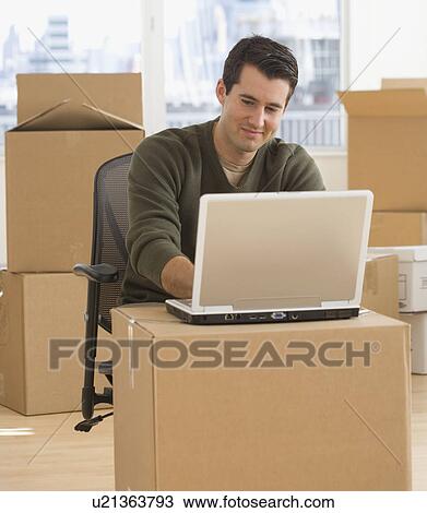 Stock Image - Businessman working in new office. Fotosearch