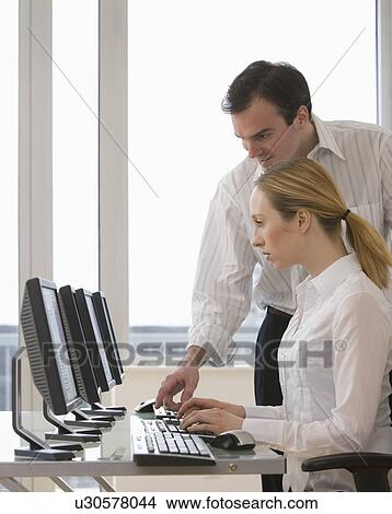 Picture - Businesspeople looking at computer. Fotosearch