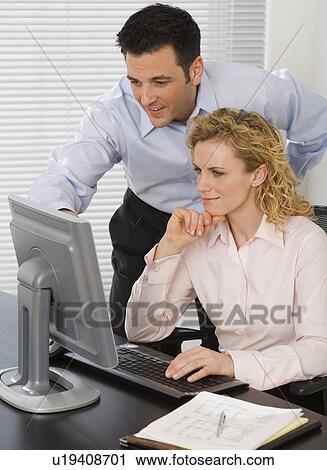 Businesspeople looking at computer View Large Photo Image Stock Image - Businesspeople looking at computer. Fotosearch