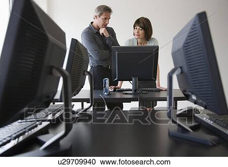 Businesspeople looking at computer View Large Photo Image Stock Image - Businesspeople looking at computer. Fotosearch