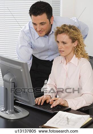 Businesspeople looking at computer View Large Photo Image Stock Photography - Businesspeople looking at computer. Fotosearch
