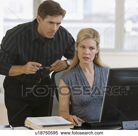 Stock Photography - Businesspeople looking at computer. Fotosearch