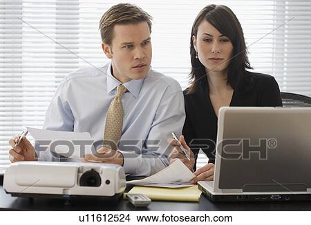Businesspeople looking at laptop View Large Photo Image Picture - Businesspeople looking at laptop. Fotosearch