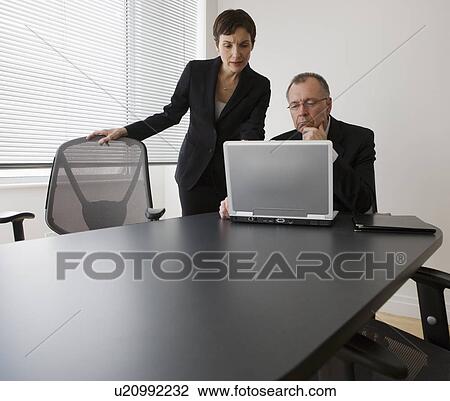 Businesspeople looking at laptop View Large Photo Image Stock Image - Businesspeople looking at laptop. Fotosearch