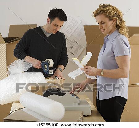 Stock Image - Businesspeople packing boxes. Fotosearch