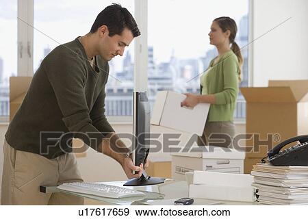 Businesspeople setting up new office View Large Photo Image Stock Photo - Businesspeople setting up new office. Fotosearch