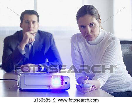Businesspeople using projector in conference room View Large Photo Image Stock Photo - Businesspeople using projector in conference room. Fotosearch