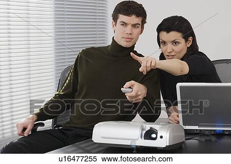Stock Photography - Businesspeople using projector. Fotosearch