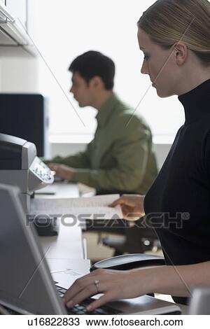 Stock Image - Businesspeople working at desks. Fotosearch