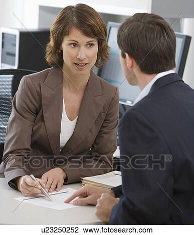 Businesswoman and businessman discussing paperwork View Large Photo Image Stock Image - Businesswoman and businessman discussing paperwork. Fotosearch