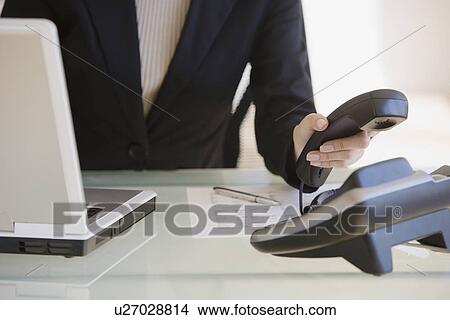 Picture - Businesswoman answering telephone. Fotosearch