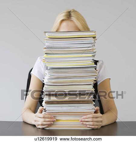 Stock Photo - Businesswoman behind stack of paperwork. Fotosearch
