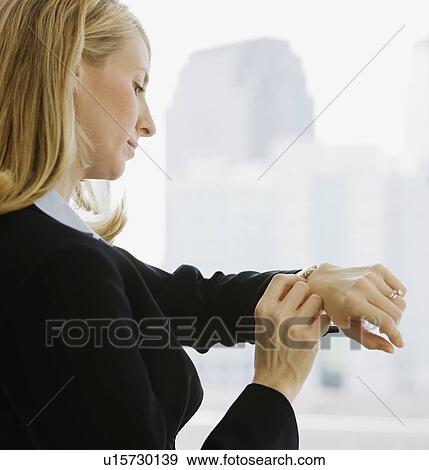 Businesswoman checking watch View Large Photo Image Stock Photo - Businesswoman checking watch. Fotosearch