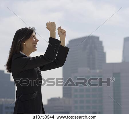 Picture - Businesswoman cheering in urban scene. Fotosearch