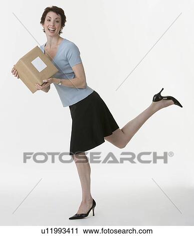 Stock Image - Businesswoman holding package. Fotosearch