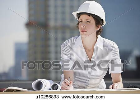 Businesswoman in hardhat drawing on blueprints View Large Photo Image Stock Image - Businesswoman in hardhat drawing on blueprints. Fotosearch
