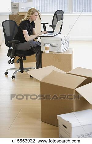 Stock Image - Businesswoman in new office. Fotosearch