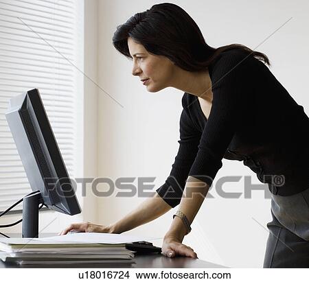 Picture - Businesswoman looking at computer. Fotosearch
