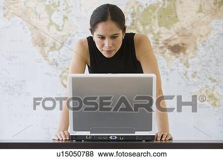 Stock Photo - Businesswoman looking at laptop. Fotosearch