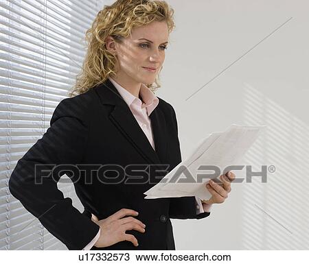 Businesswoman reading paperwork next to window View Large Photo Image Stock Image - Businesswoman reading paperwork next to window. Fotosearch