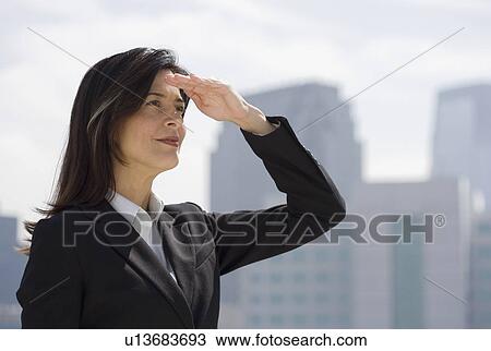 Businesswoman shielding eyes from sun View Large Photo Image Stock Image - Businesswoman shielding eyes from sun. Fotosearch