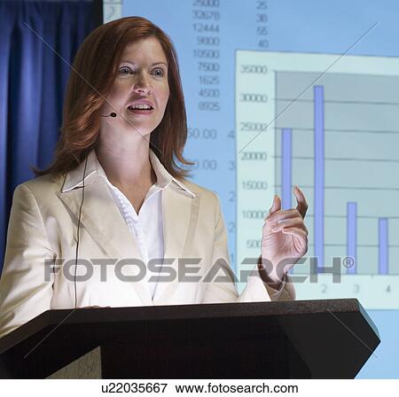 Businesswoman speaking at podium with graph in background View Large Photo Image Stock Photo - Businesswoman speaking at podium with graph in background. Fotosearch