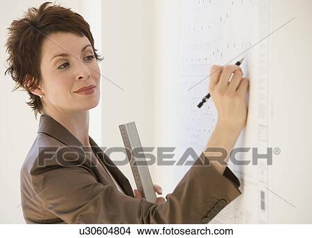 Businesswoman writing on wall chart View Large Photo Image Picture - Businesswoman writing on wall chart. Fotosearch