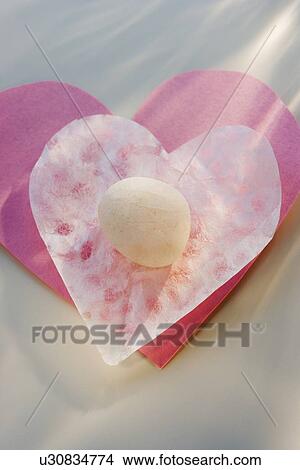 Picture - Candy on heart-shaped paper. Fotosearch