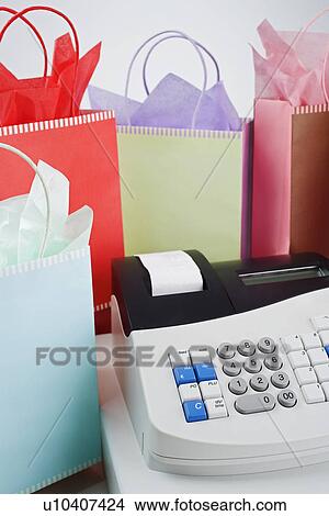 Cash register surrounded by gift bags View Large Photo Image Picture - Cash register surrounded by gift bags. Fotosearch