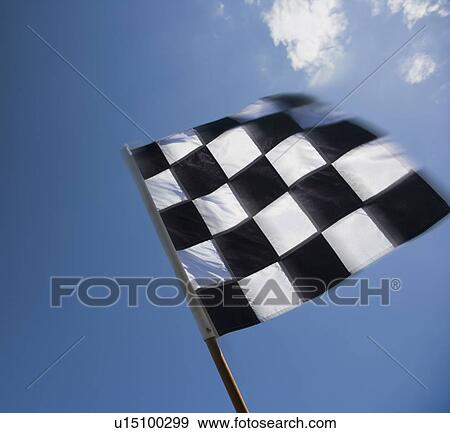 Checkered flag waving under blue sky View Large Photo Image Stock Photo - Checkered flag waving under blue sky. Fotosearch