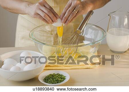 Stock Image - Chef cracking egg into bowl. Fotosearch