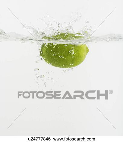 Stock Photograph - Citrus fruit dropped into water. Fotosearch