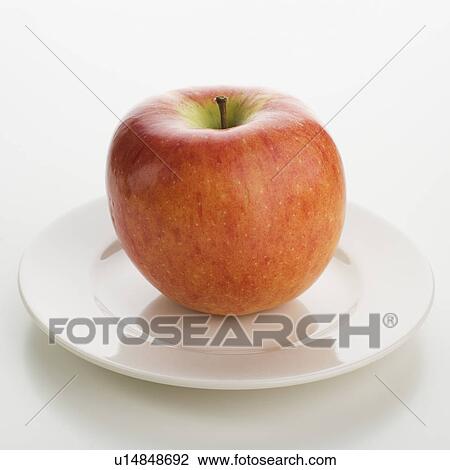 Stock Image - Close up of apple on plate. Fotosearch