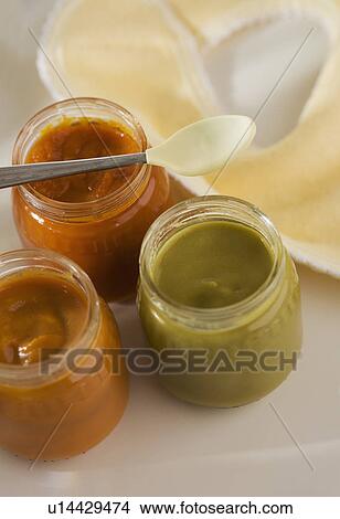 Picture - Close up of baby food in jars with spoon and bib. Fotosearch