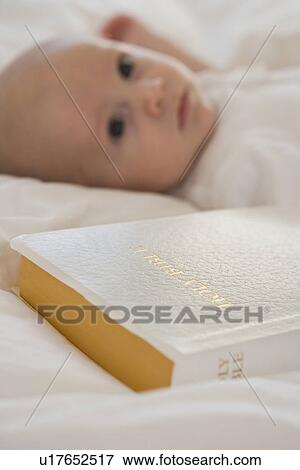 Stock Photo - Close up of Bible next to baby. Fotosearch