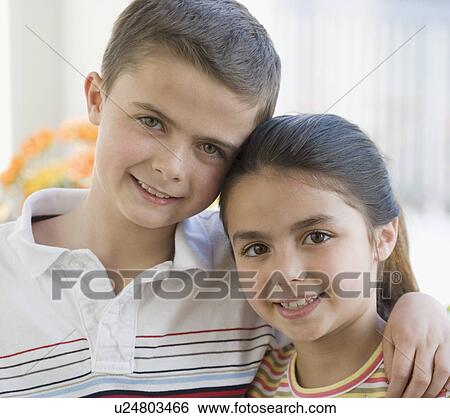 Stock Photograph - Close up of brother and sister hugging. Fotosearch